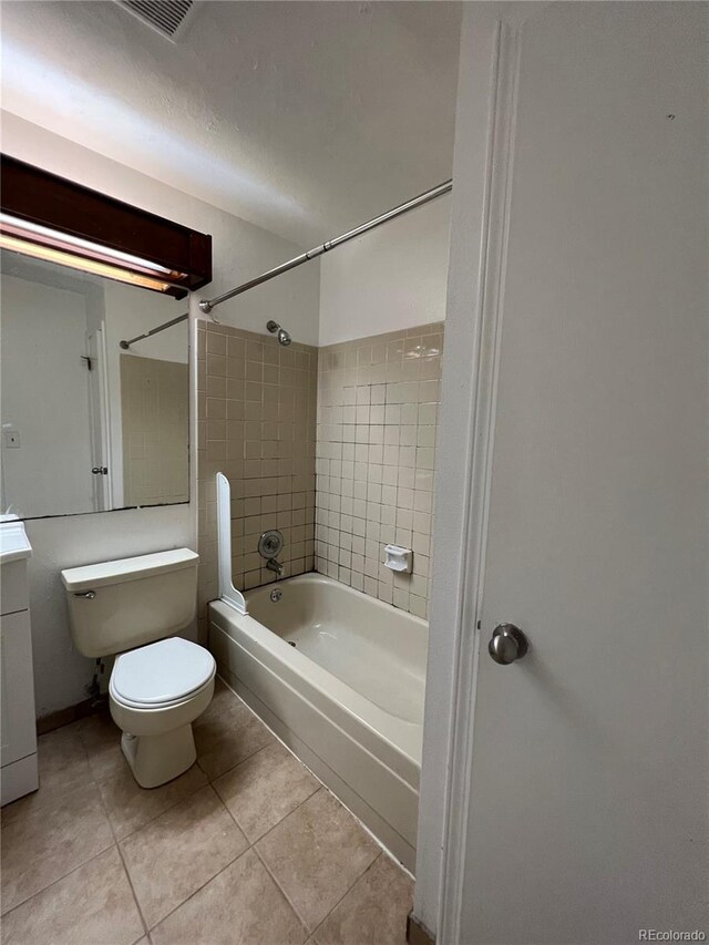 full bathroom featuring tiled shower / bath combo, tile patterned flooring, vanity, and toilet