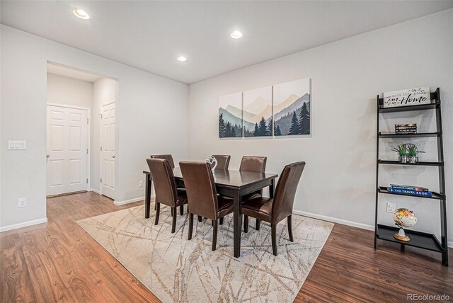 dining space featuring wood finished floors, baseboards, and recessed lighting