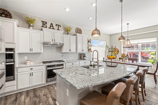 kitchen with white cabinetry, tasteful backsplash, a sink, and dark wood-type flooring
