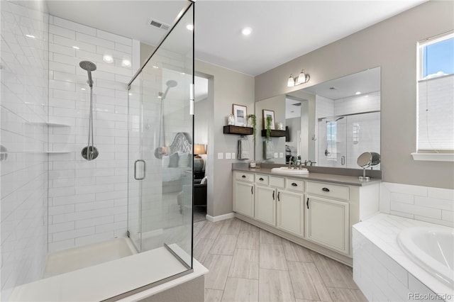 full bath with visible vents, a shower stall, a garden tub, and vanity