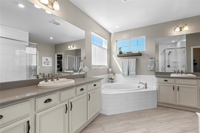 full bathroom featuring a sink, a stall shower, a garden tub, and visible vents