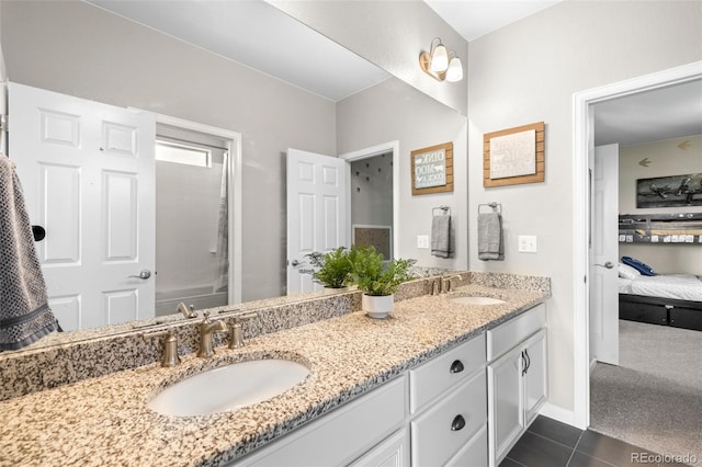 full bath with double vanity, a sink, connected bathroom, and tile patterned floors