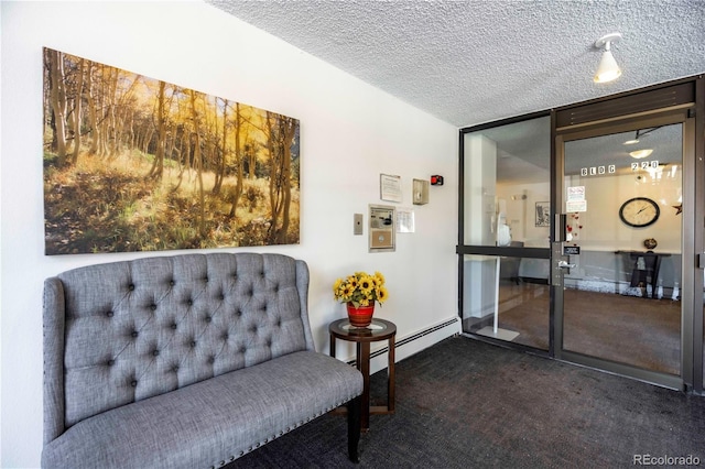 sitting room with a textured ceiling and dark colored carpet