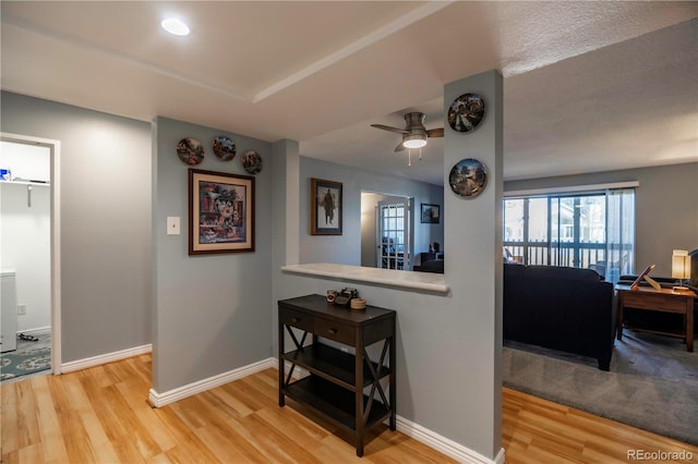 corridor featuring baseboards and wood finished floors