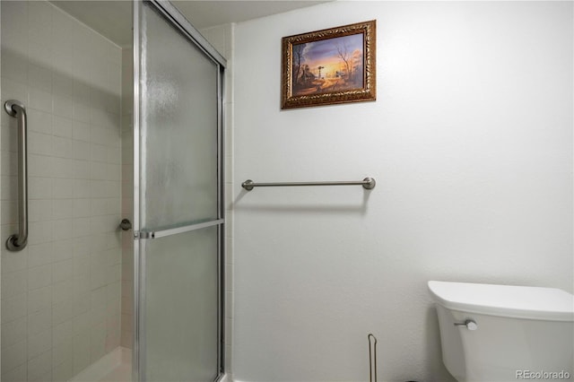 bathroom featuring tiled shower and toilet