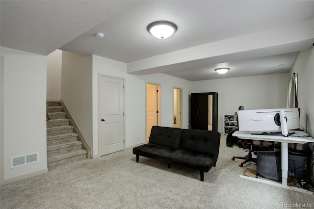 carpeted home office featuring a textured ceiling