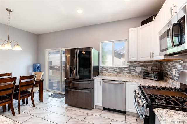5033 Goshawk Ct, Brighton, CO 80601 - kitchen featuring stainless steel appliances, a chandelier, decorative backsplash, white cabinets, and recessed lighting
