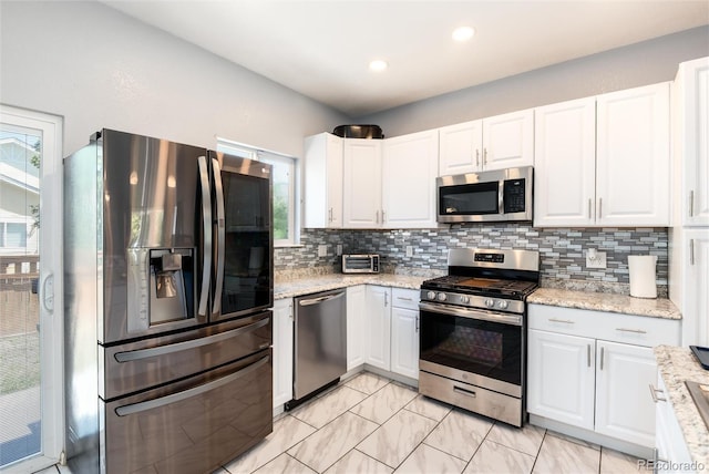 5033 Goshawk Ct, Brighton, CO 80601 - kitchen with appliances with stainless steel finishes, healthy amount of natural light, decorative backsplash, white cabinetry, and recessed lighting