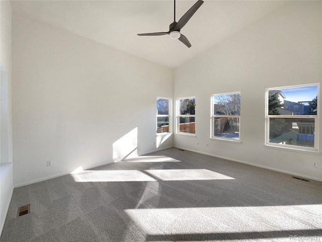 carpeted spare room featuring ceiling fan and high vaulted ceiling