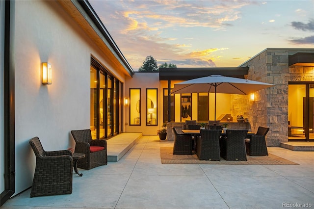 patio terrace at dusk featuring outdoor dining area