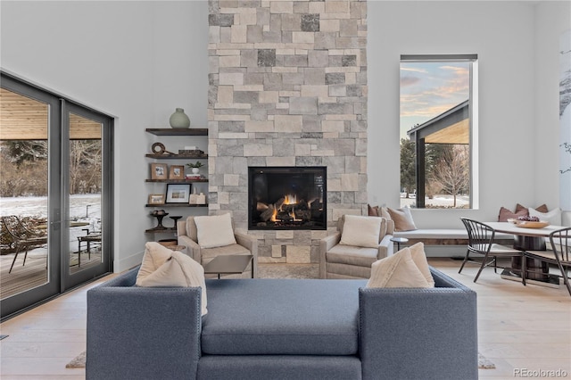 living room with light wood-style floors and a stone fireplace