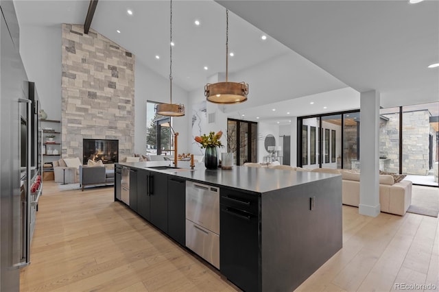 kitchen featuring dark cabinets, open floor plan, a multi sided fireplace, and light wood-type flooring