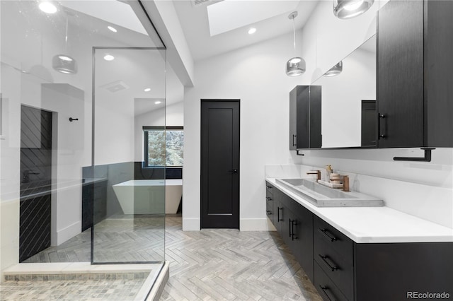 bathroom featuring lofted ceiling with skylight, a soaking tub, recessed lighting, and vanity