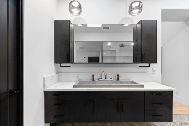 bathroom with visible vents, vanity, walk in shower, and wood finished floors