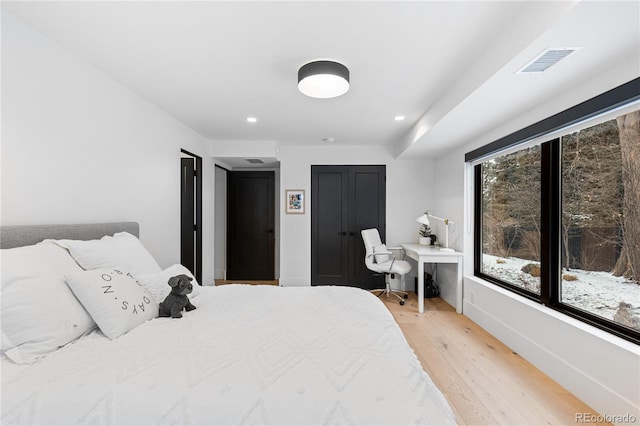 bedroom with light wood-type flooring, visible vents, baseboards, and recessed lighting