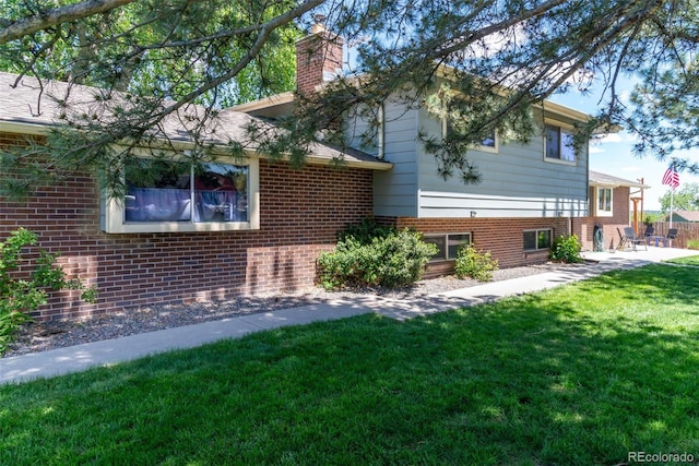 16225 W 74th Dr, Arvada, CO 80007 - view of side of property featuring brick siding, a chimney, a yard, and a patio
