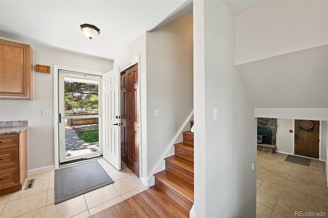 16225 W 74th Dr, Arvada, CO 80007 - entryway with stairs, light tile patterned floors, and baseboards
