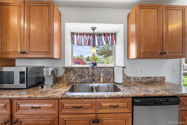 16225 W 74th Dr, Arvada, CO 80007 - kitchen with stainless steel appliances, a sink, brown cabinetry, and stone counters