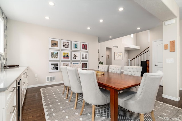 dining area featuring recessed lighting, dark wood-style flooring, visible vents, and stairs