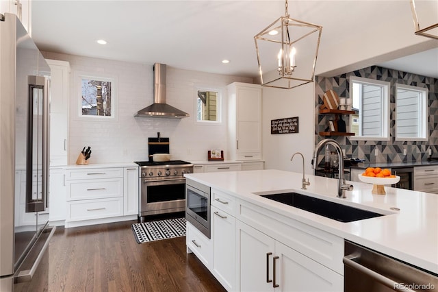 kitchen featuring wall chimney exhaust hood, light countertops, high quality appliances, and white cabinets