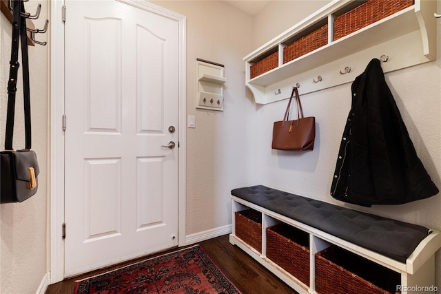 mudroom with dark wood-style flooring and baseboards