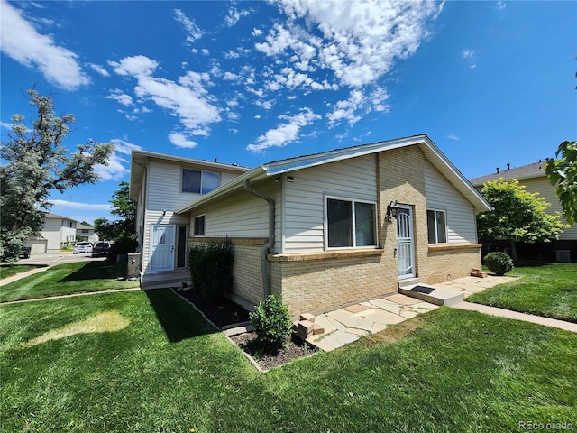 3354 S Flower St Unit 70, Lakewood, CO 80227 - view of side of property with brick siding and a lawn
