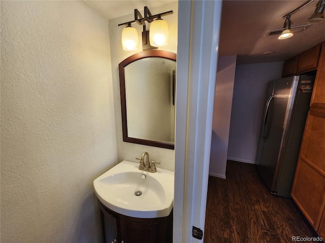 3354 S Flower St Unit 70, Lakewood, CO 80227 - bathroom featuring wood finished floors, a textured wall, and vanity
