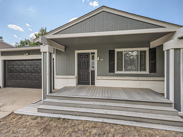 doorway to property with a garage and a porch