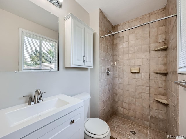 bathroom with vanity, tiled shower, and toilet