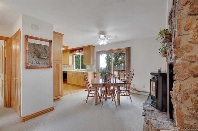 carpeted dining area featuring a wood stove, a baseboard radiator, and ceiling fan