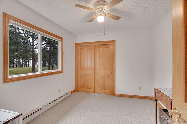 unfurnished bedroom featuring light carpet, a textured ceiling, a baseboard radiator, and ceiling fan