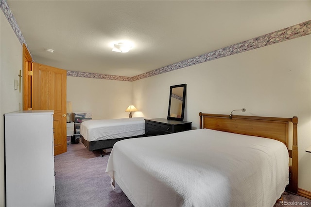 bedroom featuring a textured ceiling and dark carpet