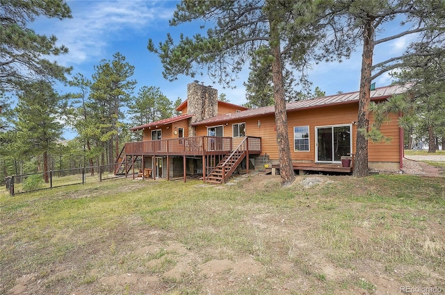 back of house with a wooden deck and a lawn