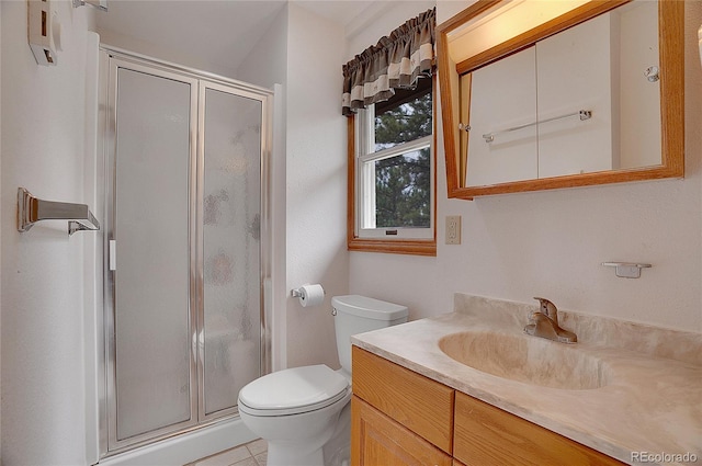 bathroom featuring a shower with shower door, tile patterned flooring, toilet, and vanity