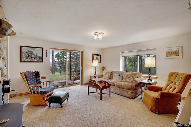 living room with a stone fireplace, light carpet, and a textured ceiling