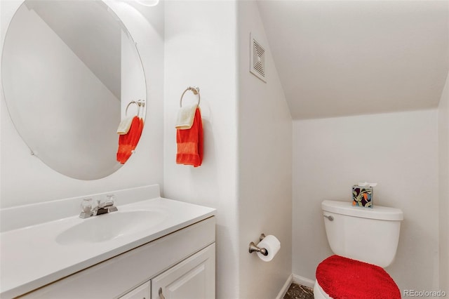 bathroom featuring vanity, toilet, and lofted ceiling