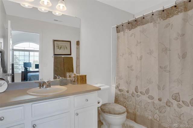 ensuite bathroom featuring visible vents, vanity, toilet, and ensuite bathroom