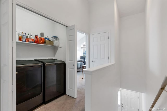 laundry room featuring washer and dryer and light carpet