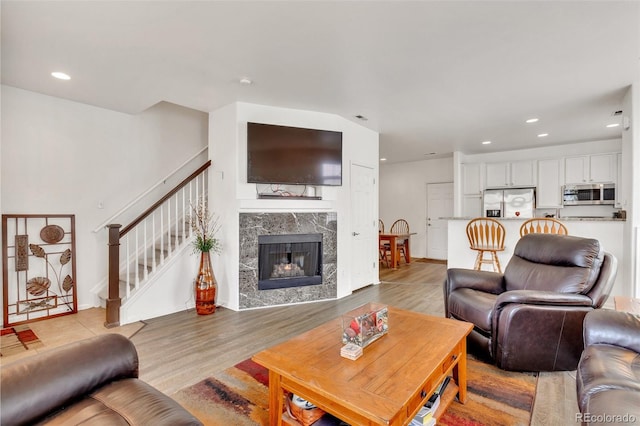 living room with light hardwood / wood-style floors and a premium fireplace