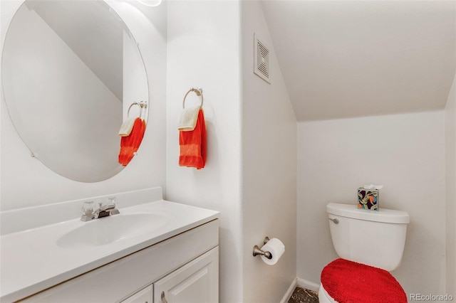 bathroom with lofted ceiling, toilet, visible vents, vanity, and baseboards