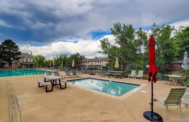 pool with a patio and fence