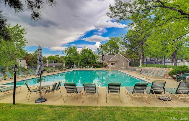 community pool with fence and a patio area