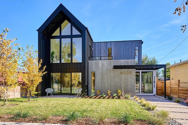 rear view of house featuring a lawn and a patio area