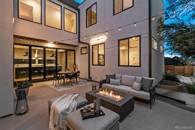 patio terrace at dusk featuring an outdoor living space with a fire pit