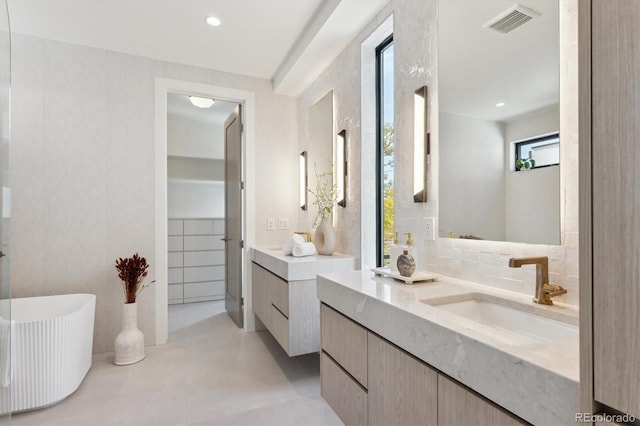 bathroom with tasteful backsplash, a bathing tub, vanity, and concrete floors