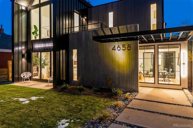 property entrance with a balcony and a yard