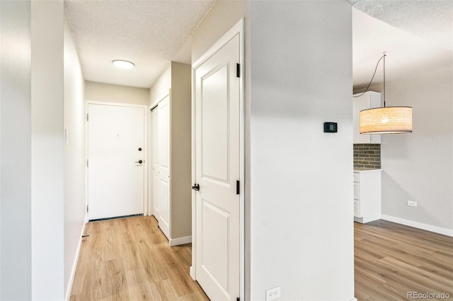 725 S Alton Way Unit 9C, Denver, CO 80247 - hallway featuring light wood-style floors and a textured ceiling