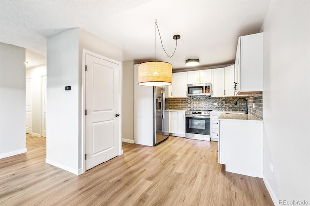 725 S Alton Way Unit 9C, Denver, CO 80247 - kitchen with appliances with stainless steel finishes, light wood-type flooring, backsplash, and white cabinets