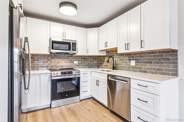 725 S Alton Way Unit 9C, Denver, CO 80247 - kitchen with stainless steel appliances, light wood finished floors, white cabinets, and tasteful backsplash