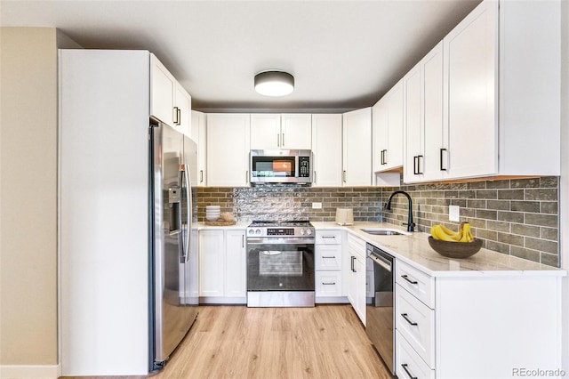 725 S Alton Way Unit 9C, Denver, CO 80247 - kitchen with appliances with stainless steel finishes, light wood-type flooring, light stone countertops, and white cabinetry